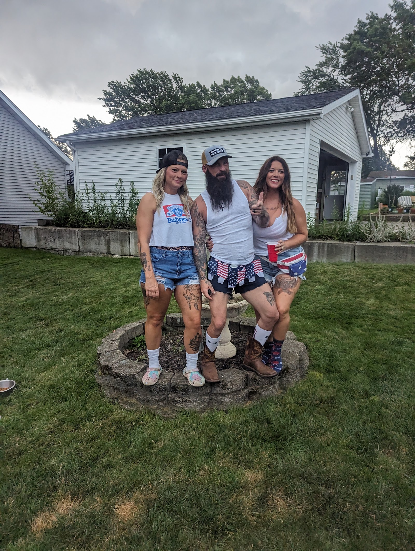 Three guests posing by the fire pit in jorts and cowboy boots